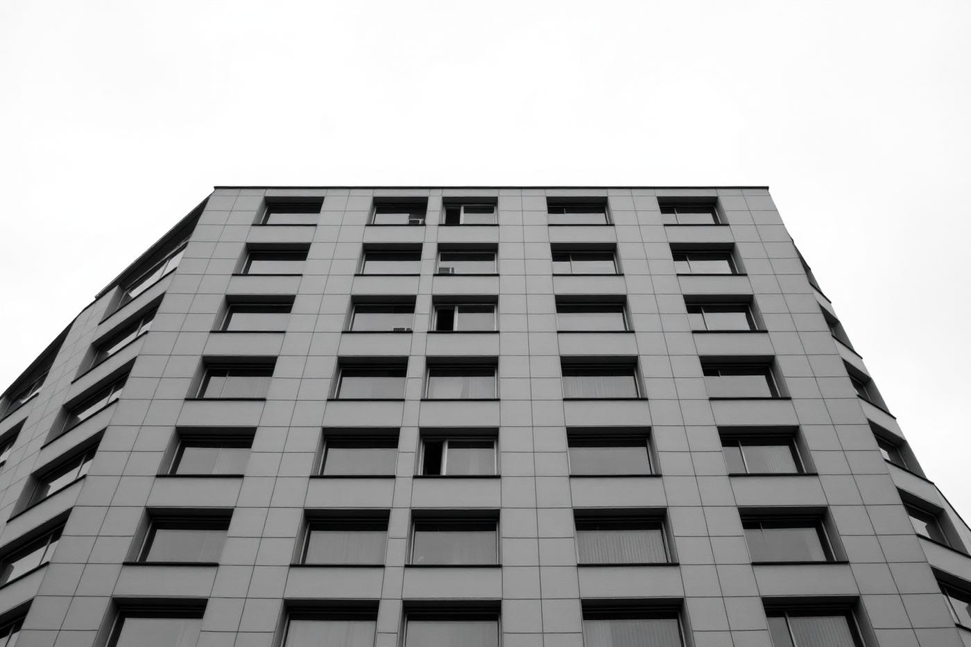 Modern European office building photographed from below, showing a regular grid facade